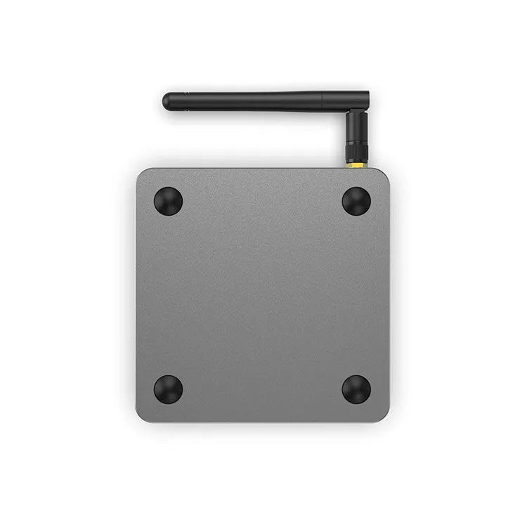 Android smart TV set-top box with remote control and HDMI cable on a wooden surface.