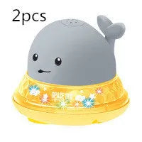 Automatic water-spraying whale bath toy with colourful lights floating in bath water.