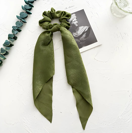 Spring dark green cloth ribbon hair tie tied in a large knot, showing seiko-treated fabric and floral detail.