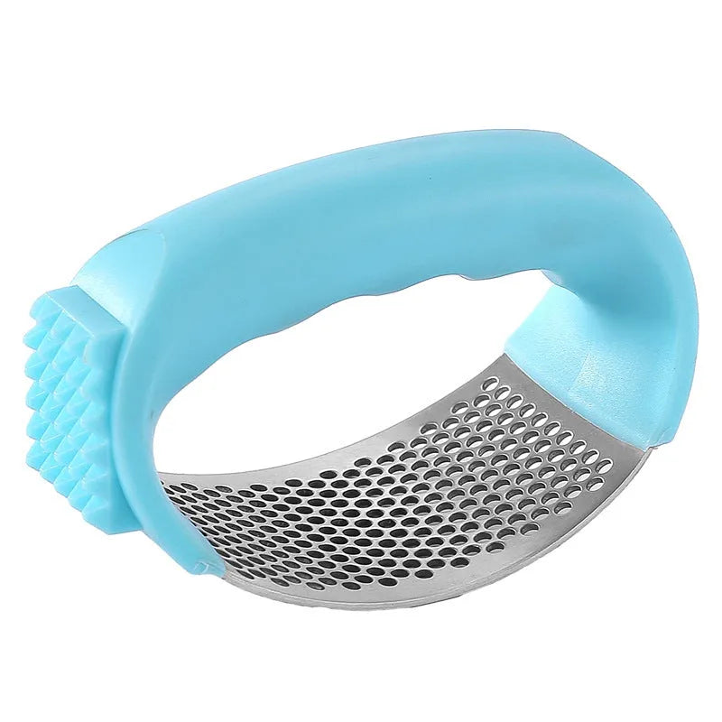 Stainless steel garlic press with coloured handles in a modern design, shown on a kitchen counter.