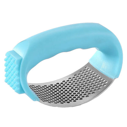 Stainless steel garlic press with coloured handles in a modern design, shown on a kitchen counter.