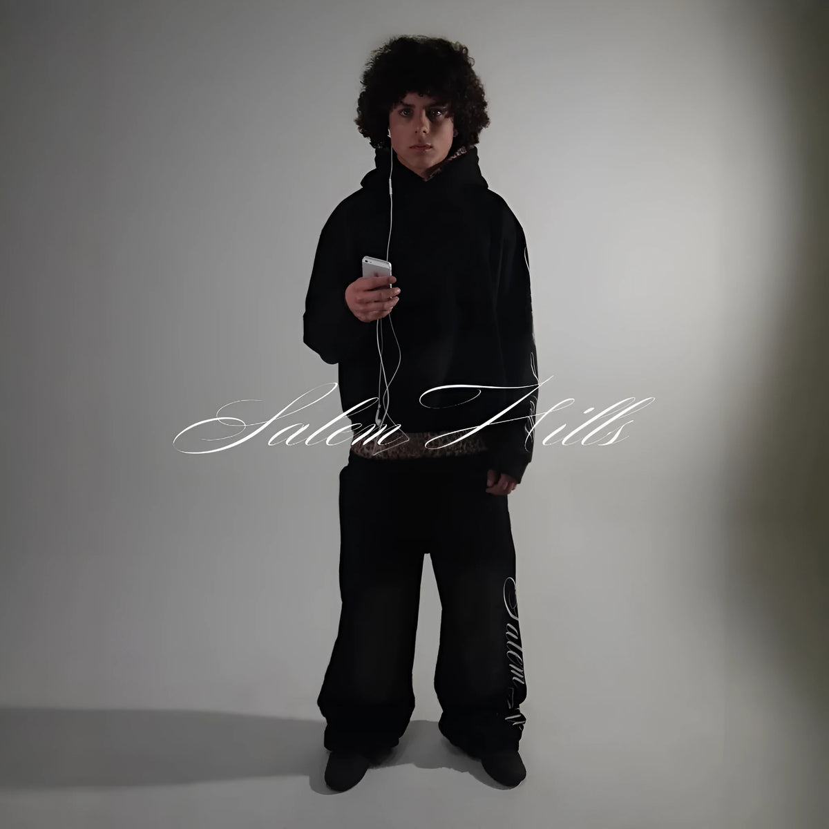 Man wearing a black punk print hoodie and matching trousers, a casual lounge suit set.