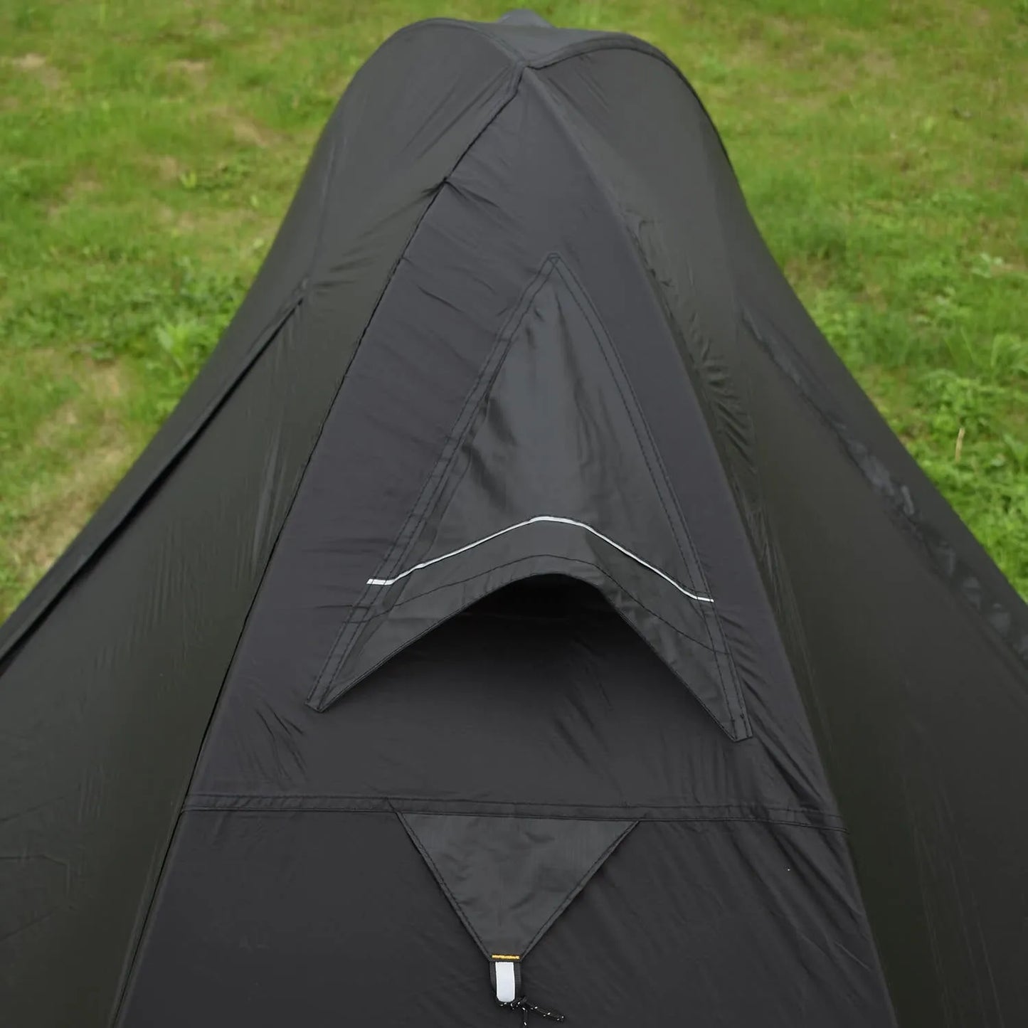 Single person tent with aluminium poles, silicon coating, and double-layer design in black colour, set up outdoors