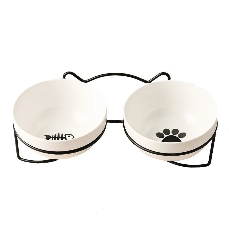White ceramic pet bowl with cat paw design on a black iron frame raised feeder.