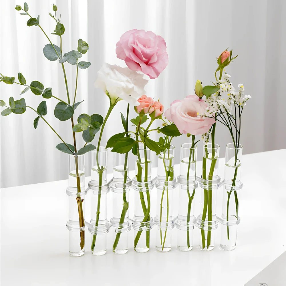 Clear glass hinged test tube vase with plants in curved arrangement