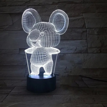 Black Koala night light with LED illumination on a bedside table.