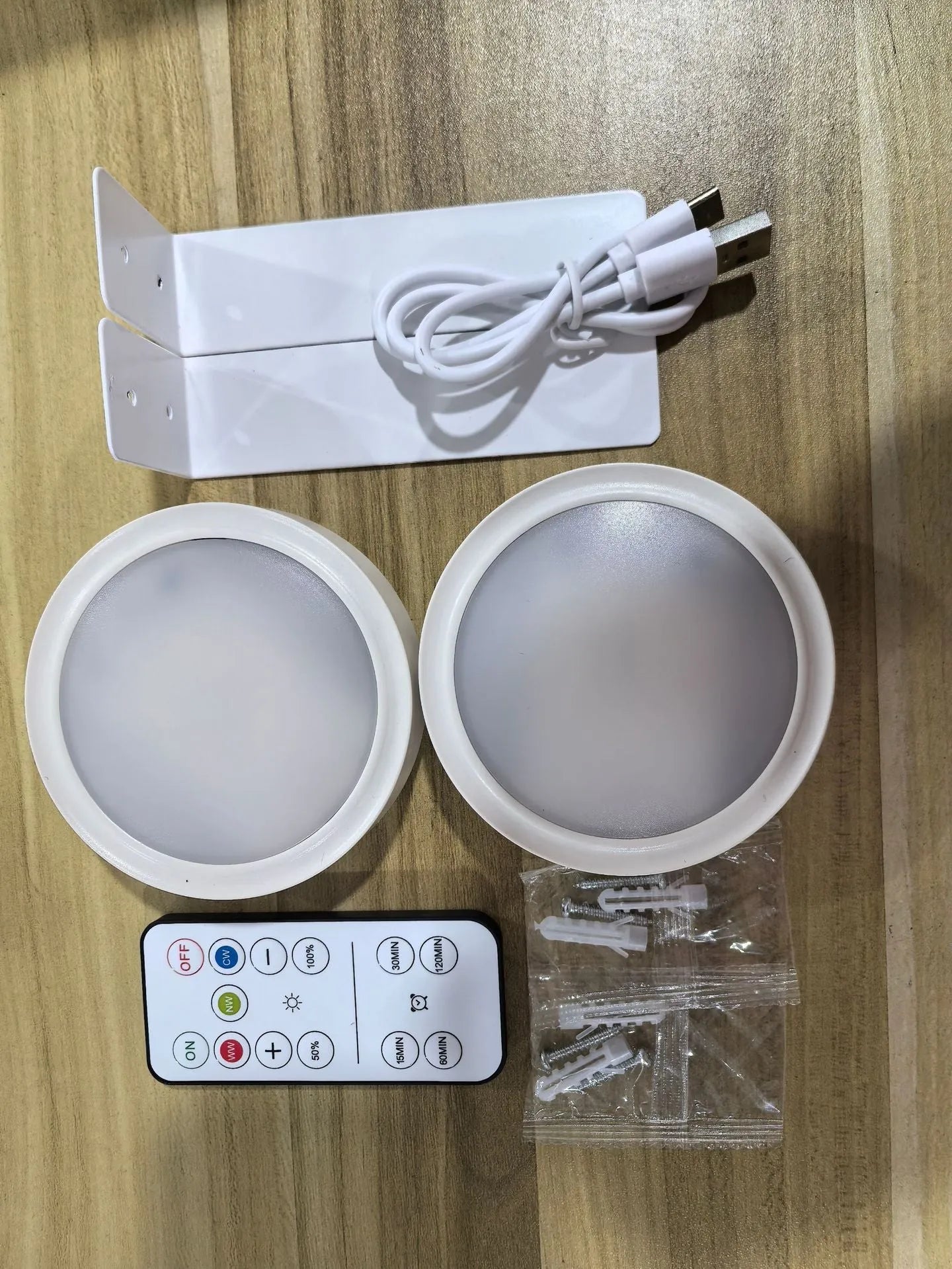 Black magnetic LED painting lamp with remote control on a white wall.