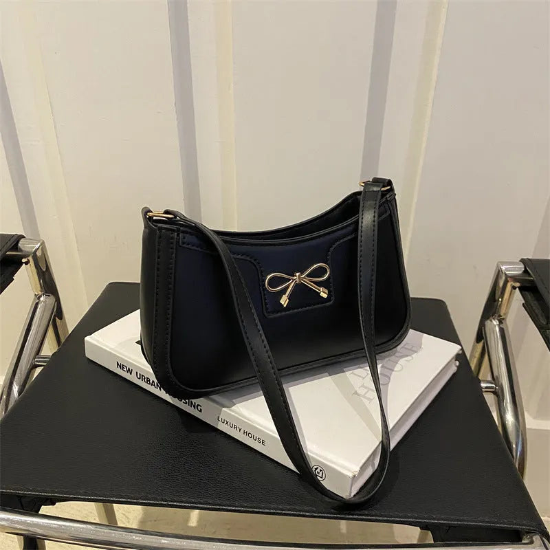 Western style shoulder bag with bow detail in rose pink colour, showing horizontal square shape and single strap.