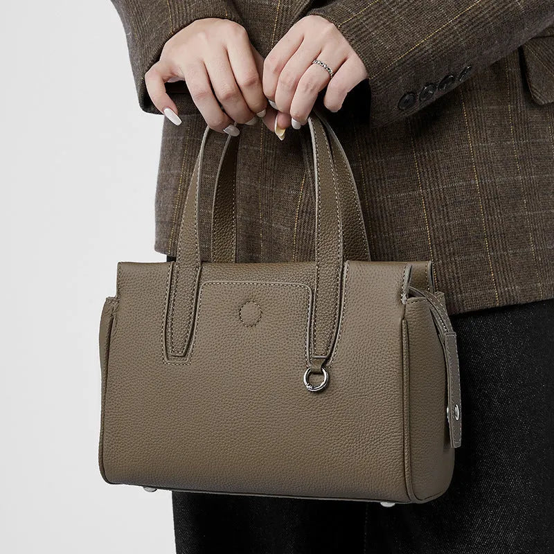 Cowhide portable crossbody bag with large capacity and single adjustable shoulder strap, horizontal square suitcase shape made from genuine leather with medium hardness, featuring polyester cotton lining and available in black, brown or grey colour