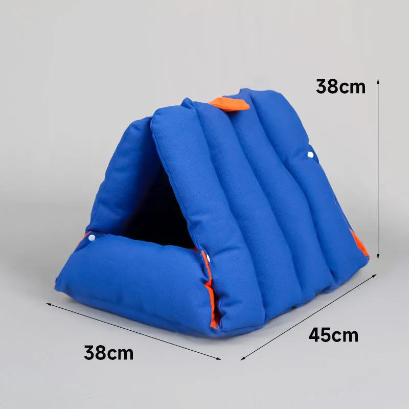 Blue triangular cotton cat bed with a removable cover on a wooden floor.