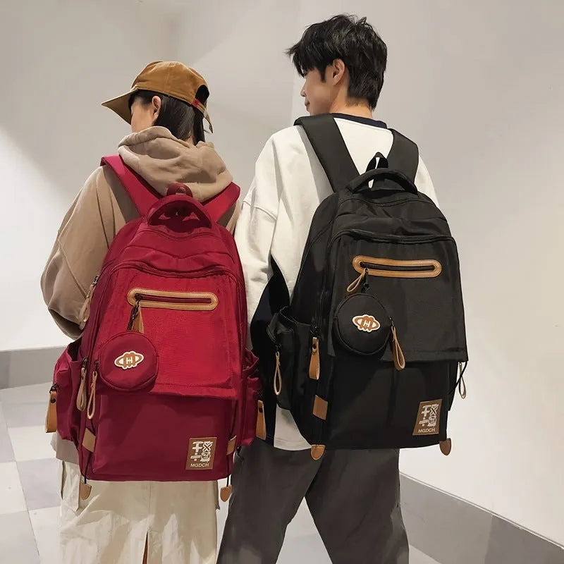 Large nylon school backpack for middle school students in a solid colour with curved shoulder straps.