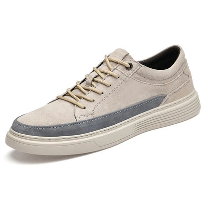 Men's grey low-top casual leather skate shoes with round toe and flat rubber sole on a wooden surface.