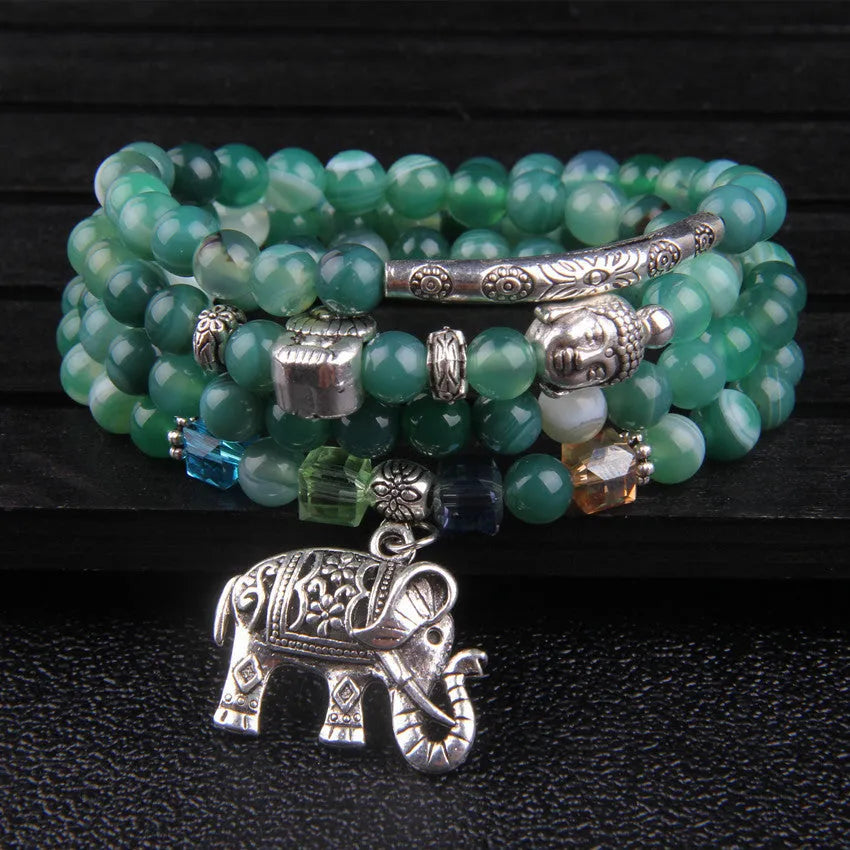 Multi-layer agate amulet bracelet with 6mm beads in blue elephant pattern on a wrist.