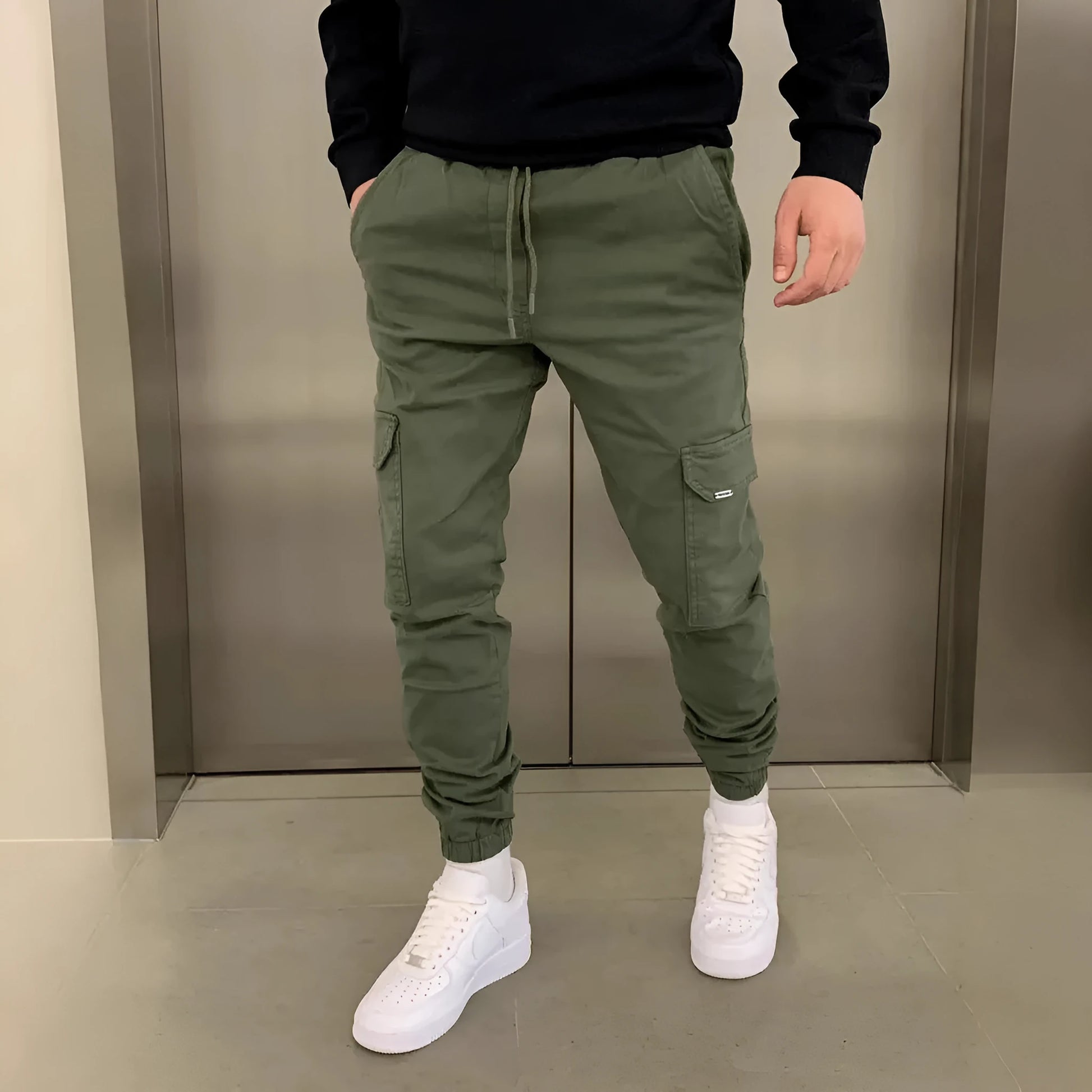 Men's loose-fit casual trousers with elastic waistband and patch pockets in army green colour