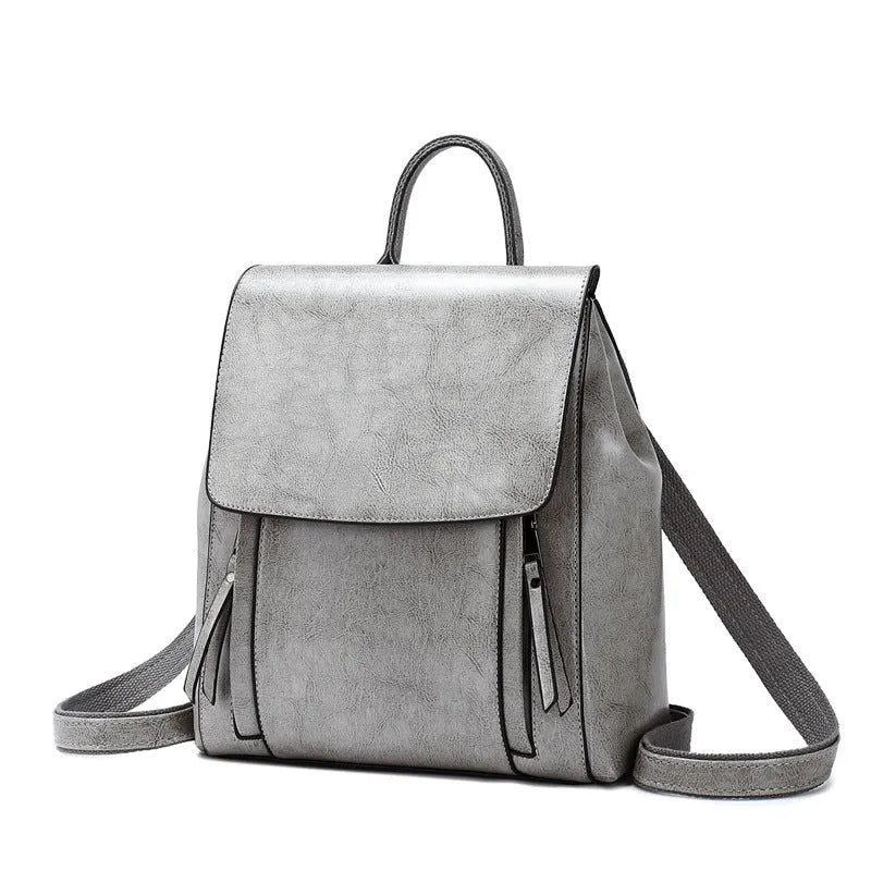Genuine leather women's backpack with multiple compartments showing stitching details and cover-type opening