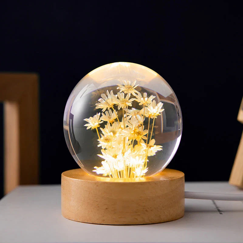 Enchanting 3D dandelion, yellow daisy, or red daisy flowers suspended in a clear crystal ball with a beech wood base, creating a mesmerizing desktop decor piece.