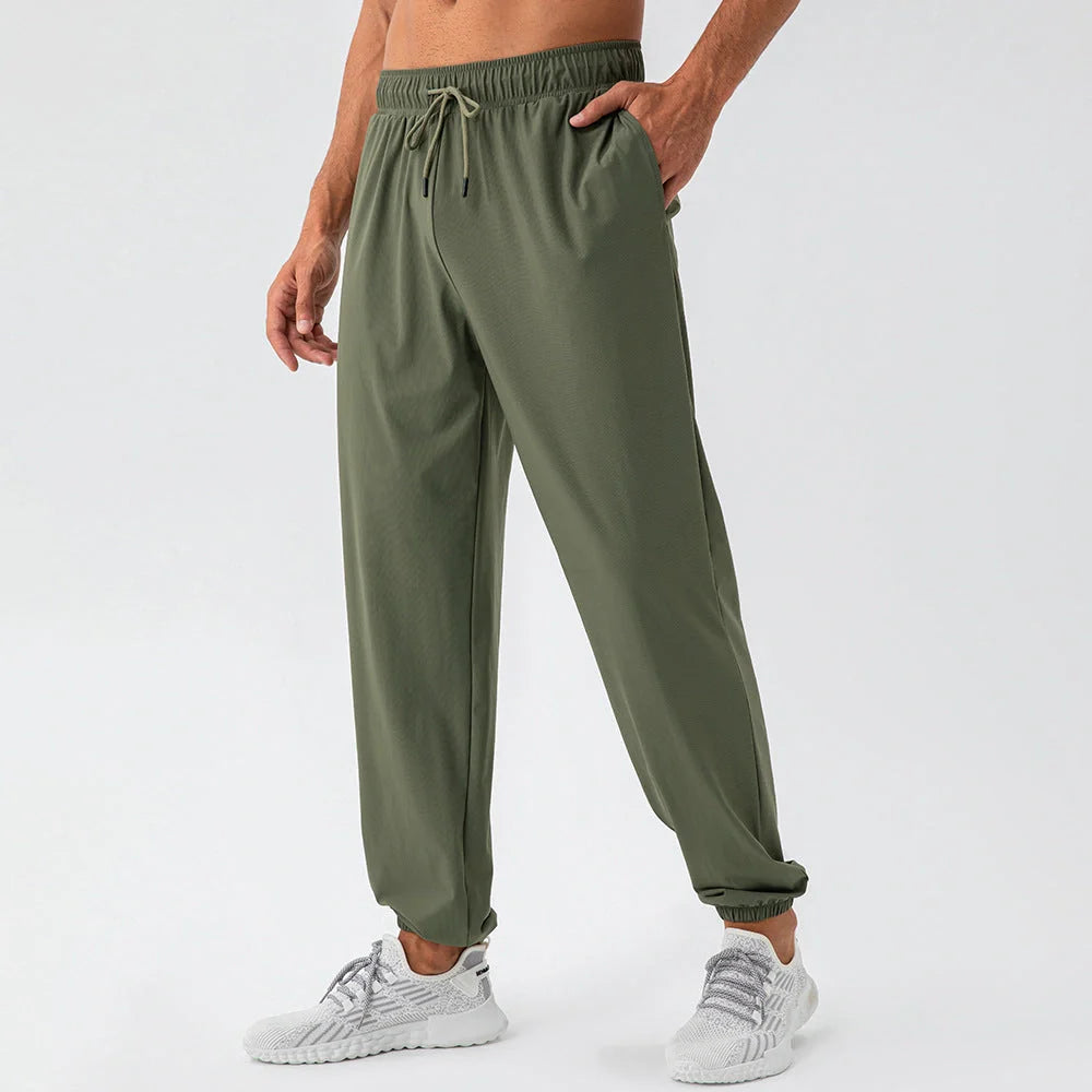 Men's lightweight nylon track pants in various colors, featuring a relaxed, flexible fit for active lifestyles