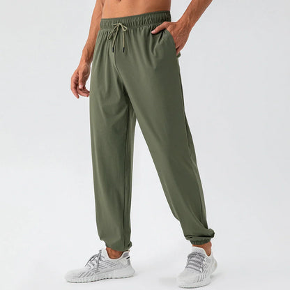 Men's lightweight nylon track pants in various colors, featuring a relaxed, flexible fit for active lifestyles