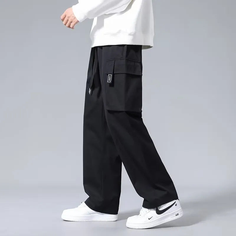 Boys in straight leg cargo trousers with drawstring waist and large side pockets, shown in Army Green.