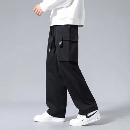 Boys in straight leg cargo trousers with drawstring waist and large side pockets, shown in Army Green.