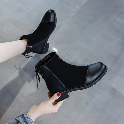 Women's black knee-length Martin boots with side zipper, non-slip rubber sole, and bow detail on microfiber upper