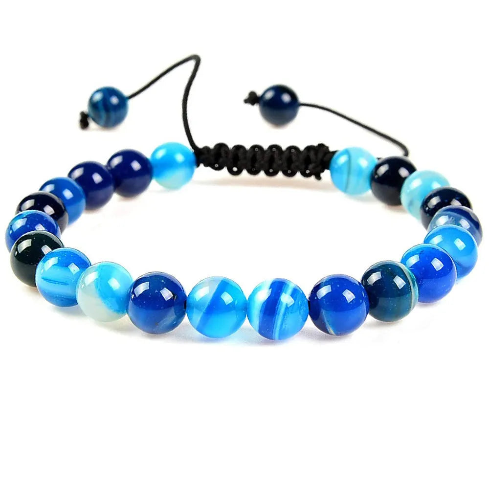 Close-up of a women's flat knot braided healing bracelet hand-woven with colourful gemstones.