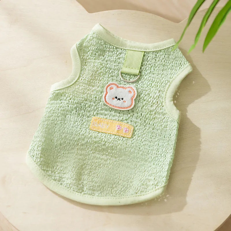 Green knitted cat clothing with a cartoon bear patch, showing hollowed-out breathable design.