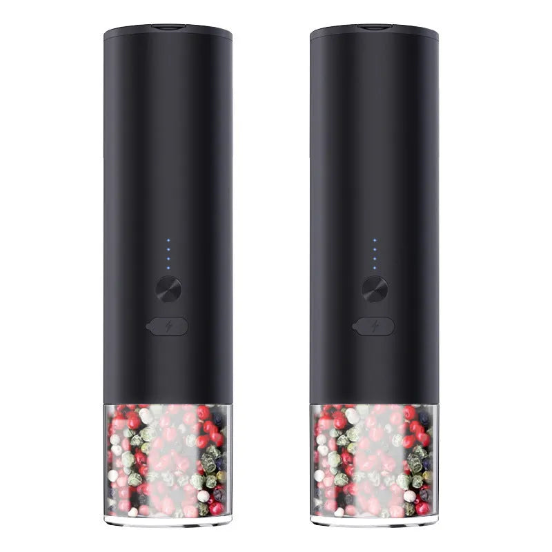 White electric salt and pepper grinder with stainless steel top and clear glass jar on a kitchen counter.