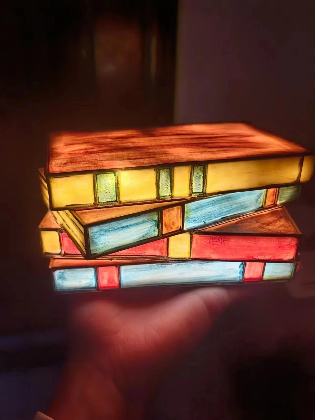 Elegant vintage-inspired table lamp with stacked book design and handcrafted glass panels, creating a warm, ambient lighting solution for reading nooks and living spaces.