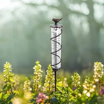 Cast iron hummingbird-shaped rain gauge with glass measurement tube showing 1-20 scale markings