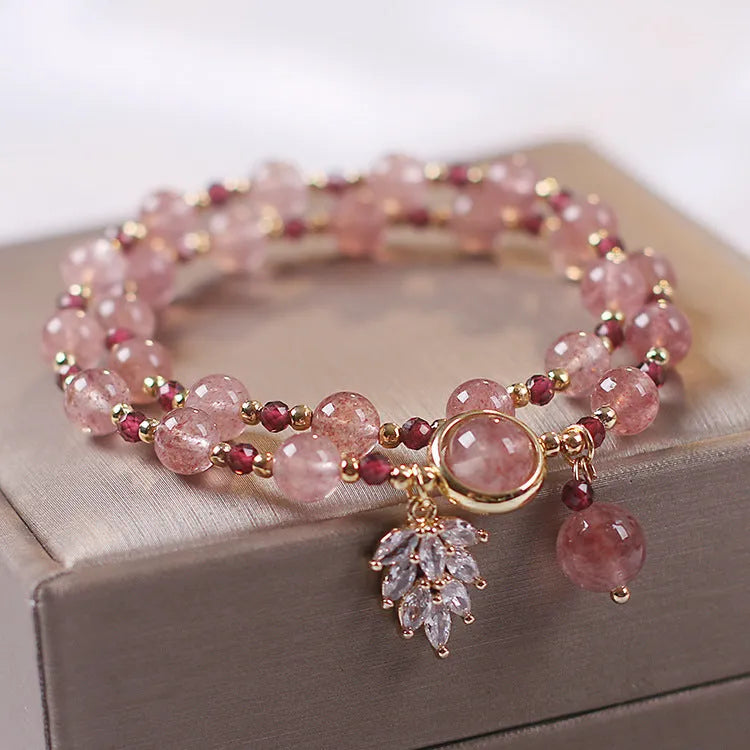 Double-layer strawberry quartz crystal bracelet with lucky cat charm and red cat's eye flowers design.