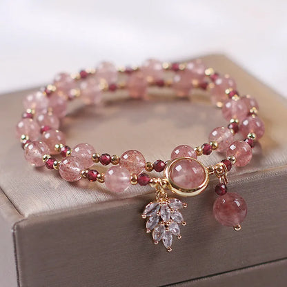Double-layer strawberry quartz crystal bracelet with lucky cat charm and red cat's eye flowers design.