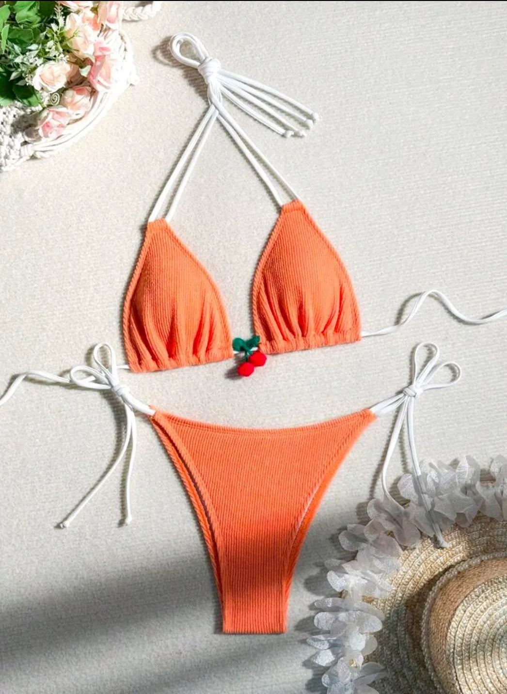 Solid colour briefs-style bikini swimsuit on a hanger, showing the top and pants.