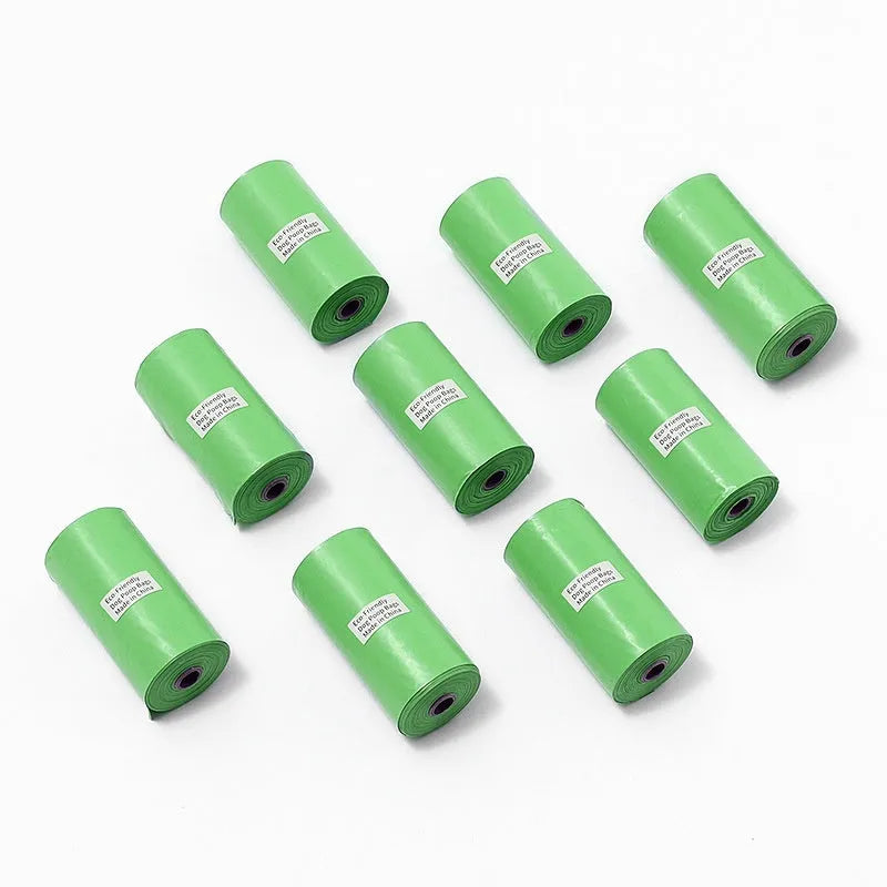 Roll of EPI green degradable pet waste bags next to a transparent dispenser on a grass background.