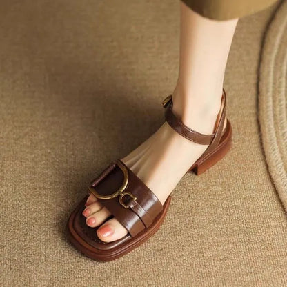 Women's black leather sandals with a thick rubber sole and button fastening on a round toe.