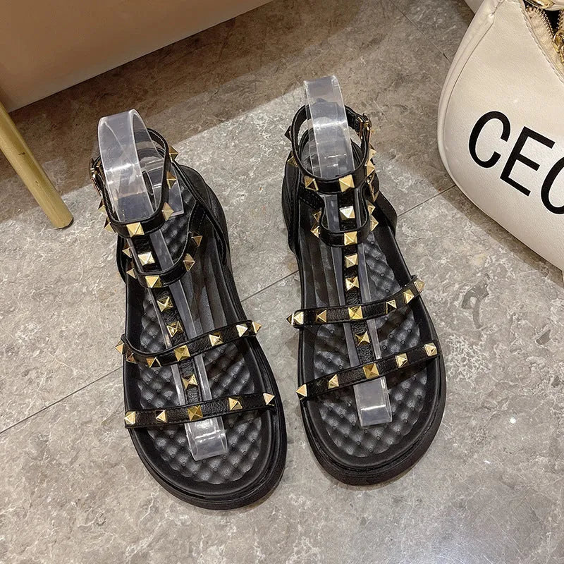 Women's Roman-style flat sandals with round toe, rivet platform, ankle buckle, PU upper, rubber sole, beige or black.