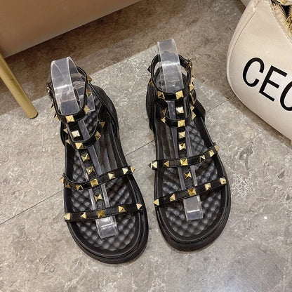 Women's Roman-style flat sandals with round toe, rivet platform, ankle buckle, PU upper, rubber sole, beige or black.