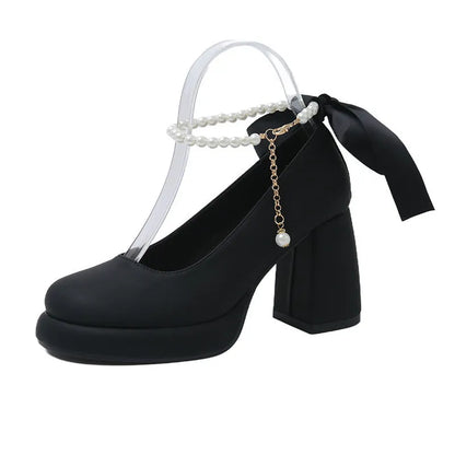 Women's beige Mary Jane shoes with chunky heel, ankle strap, pearl buckle, and round toe on a rubber sole.