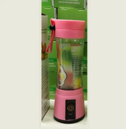 Compact pink portable blender with USB charging cable and box, shown alongside blended fruit smoothie.