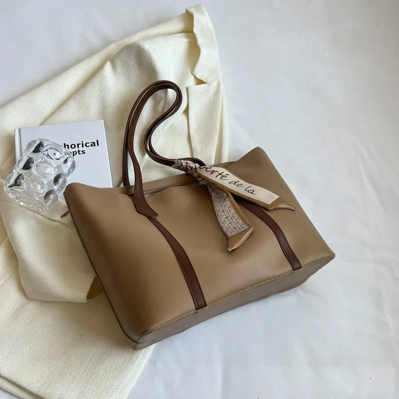 Soft large-capacity bucket tote bag with shoulder strap and zip pocket, shown in a neutral colour.