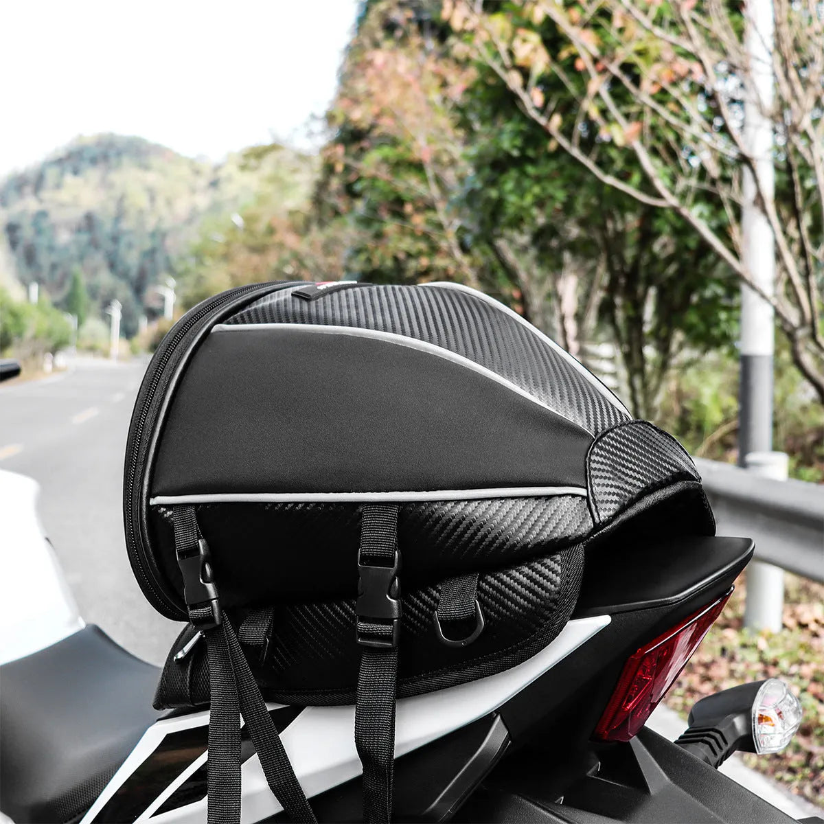 Black waterproof motorcycle tail bag with reflective stripe, showing multiple pockets and a carrying strap.