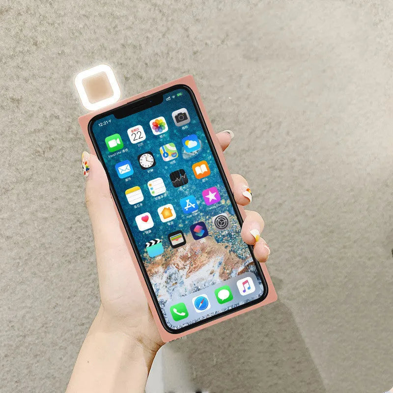 Pink mobile phone case with built-in ring flash light for Apple iPhone 13 models on a white background.