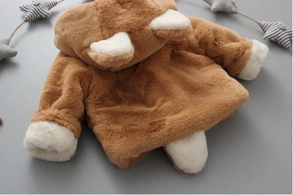 Baby wearing pink cotton coat with velvet accents, showing flocking fabric texture and cotton filling insulation