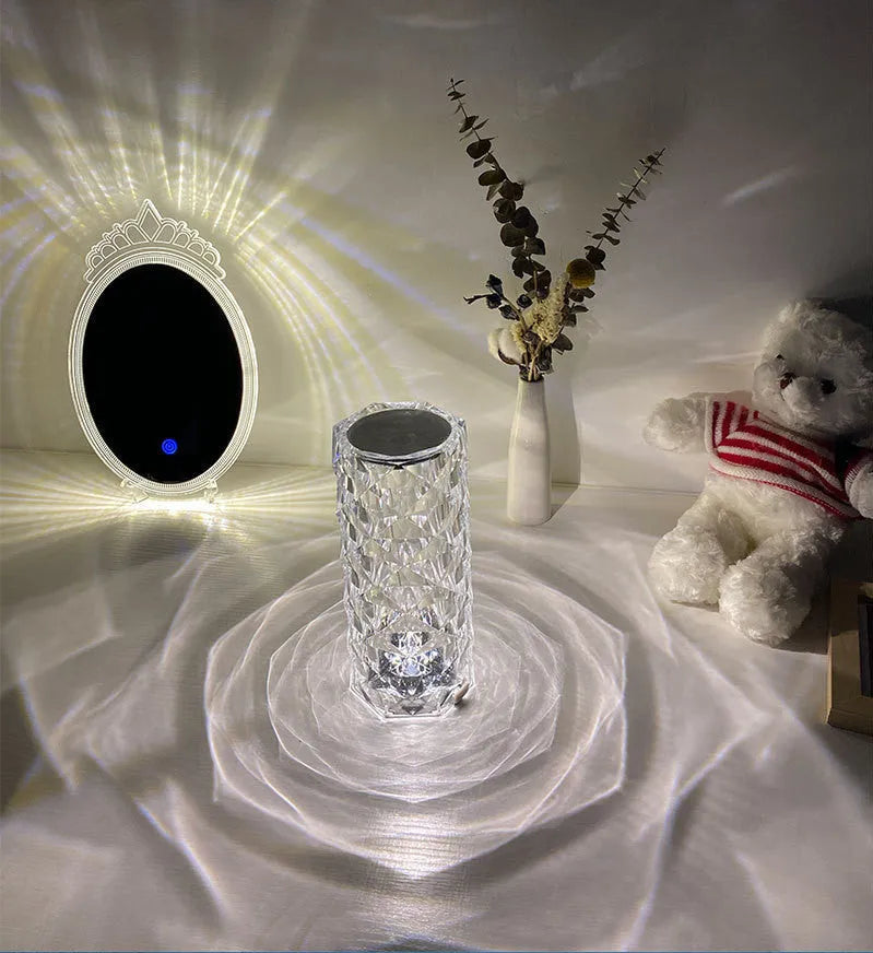 Modern minimalist acrylic crystal rose LED table lamp with touch switch on a wooden table.