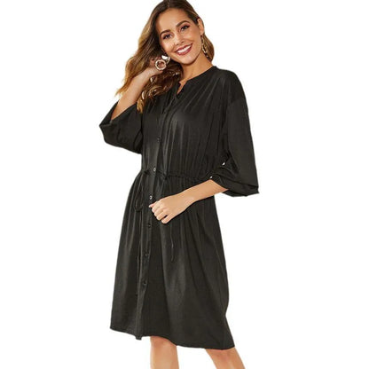 A-line mid-length dress with elastic waist, cinched belt, and long sleeves in solid black or red colour
