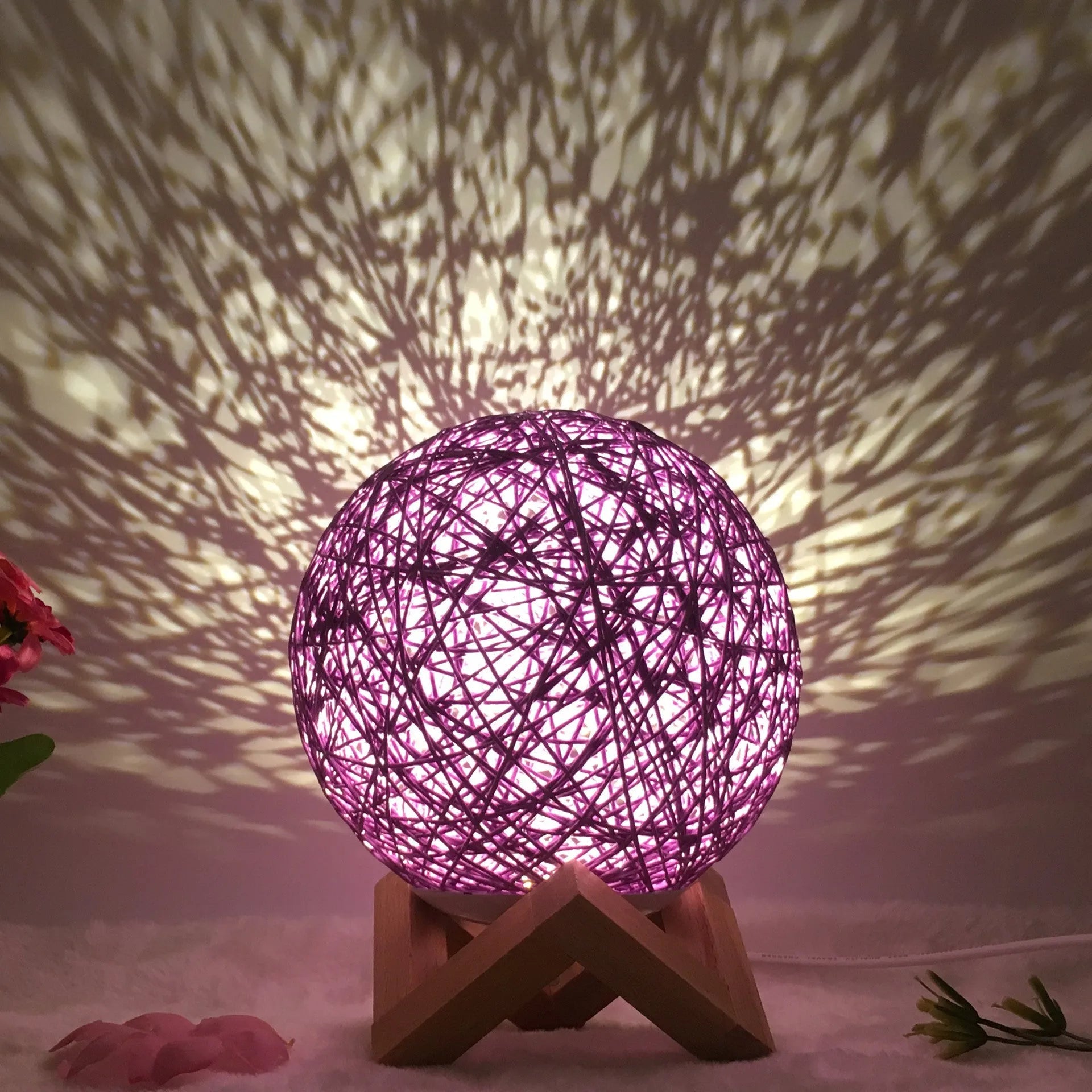 Spherical hand-knitted rattan table lamp with remote control on a wooden desk