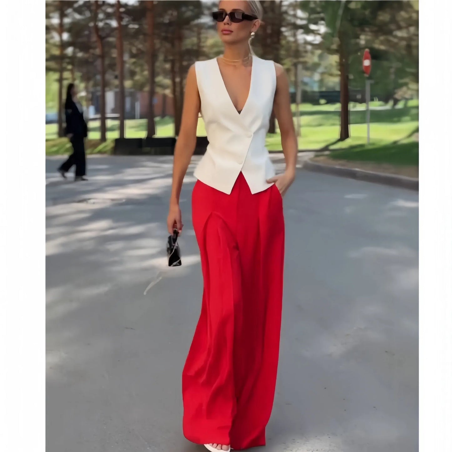 Beige women's two-piece set with sleeveless V-neck top and high-waist wide-leg trousers on a hanger.