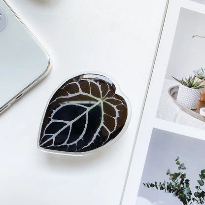 Stylish leaf-inspired smartphone stand with secure grip and adjustable viewing angle for hands-free use