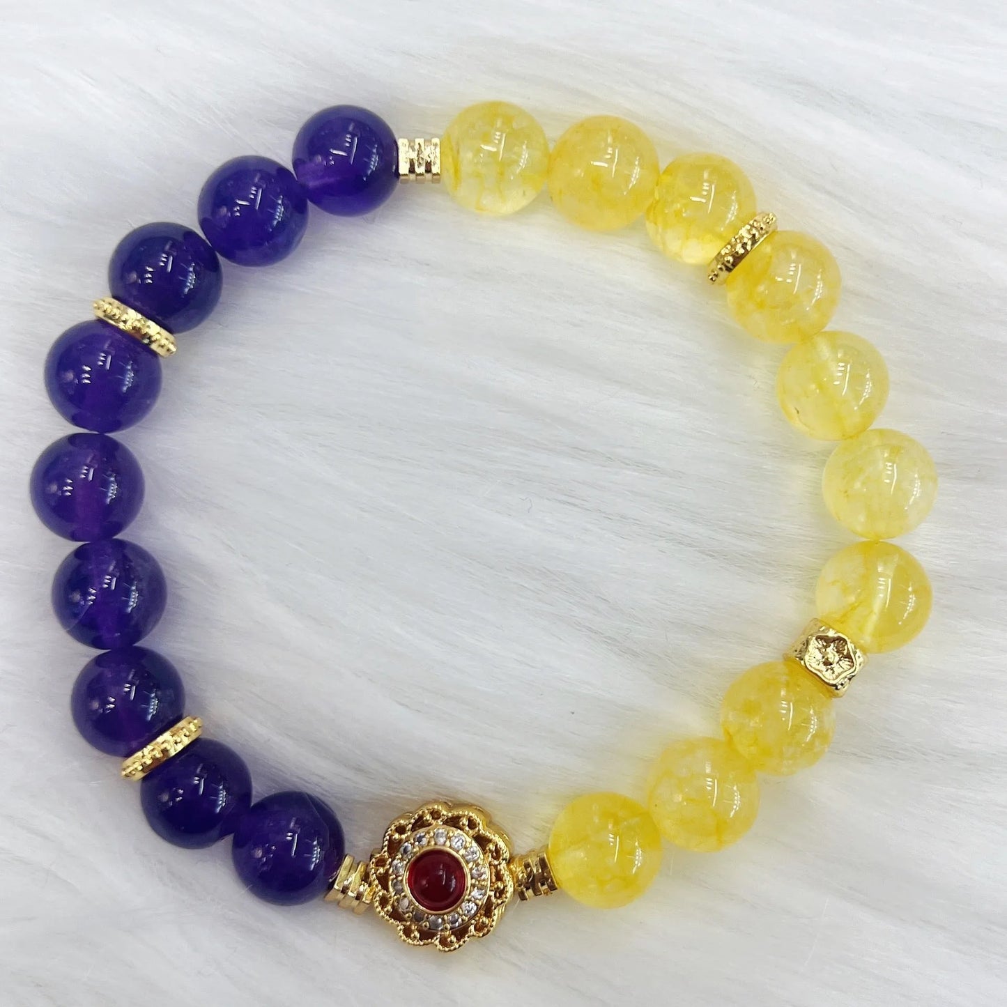 Handmade women's crystal bracelet in yellow and purple colours on a wrist.