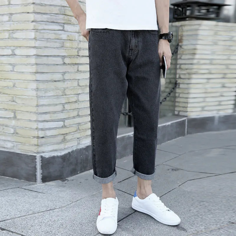 Men's black harem jeans with loose straight fit and straight leg design on a hanger